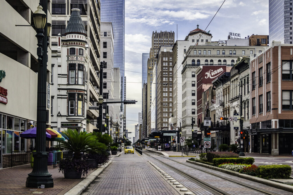 A view of downtown Houston's Main Street, which is flanked with skyscrapers and buzzing with activity.