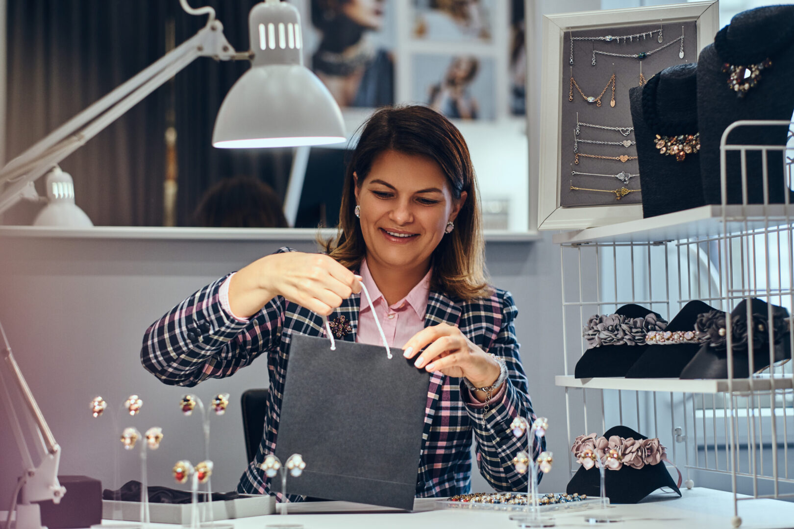 What We Do 12 portrait happy elegantly dressed woman seller packs precious earrings box her client luxury jewelry store scaled